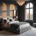 A luxurious master bedroom interior at golden hour, featuring deep charcoal gray walls, a king-size velvet headboard bed, layered silk and velvet bedding, and warm light from a crystal chandelier reflecting off an oversized ornate mirror, with flowing silk drapes and brass accents.