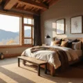 Cozy mountain retreat bedroom with a king-sized bed, reclaimed wood headboard, and soft natural lighting, featuring a stone fireplace, distressed leather armchair, and vintage copper lanterns.