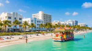 Why January is Miami's Best-Kept Travel Secret (And Why You Need to Go NOW) "Art Deco buildings and palm trees lining a Miami beach with sunbathers and swimmers in turquoise waters, under a clear sky in January, as a colorful King Mango Strut Parade float with costumed performers passes in the foreground."