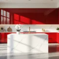 Photorealistic image of a luxurious modern kitchen featuring vibrant cherry red cabinets, white quartz countertops, a large island, stainless steel appliances, and brushed gold hardware, illuminated by warm natural light through floor-to-ceiling windows, with polished concrete floors and minimal styling.