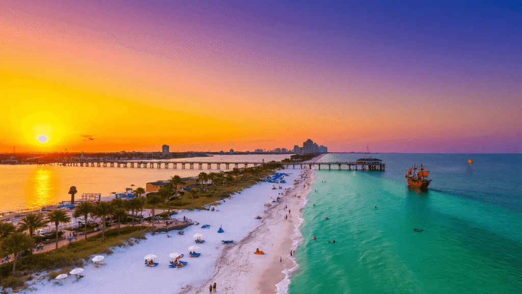 Escape to Paradise: The Ultimate Clearwater Adventure Guide You Can't Miss "Aerial view of Clearwater Beach at sunset with Pier 60, palm trees, white umbrellas, dolphins, parasailers, beachgoers, a pirate ship cruise, and Clearwater skyline"