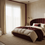 A luxurious cocoon-style bedroom with burgundy velvet upholstered walls, cream linen bedding, mohair throws, and silk pillows, bathed in golden hour light, featuring a terracotta accent wall, modern curved bed frame, layered rugs, and warm brass pendant lighting.